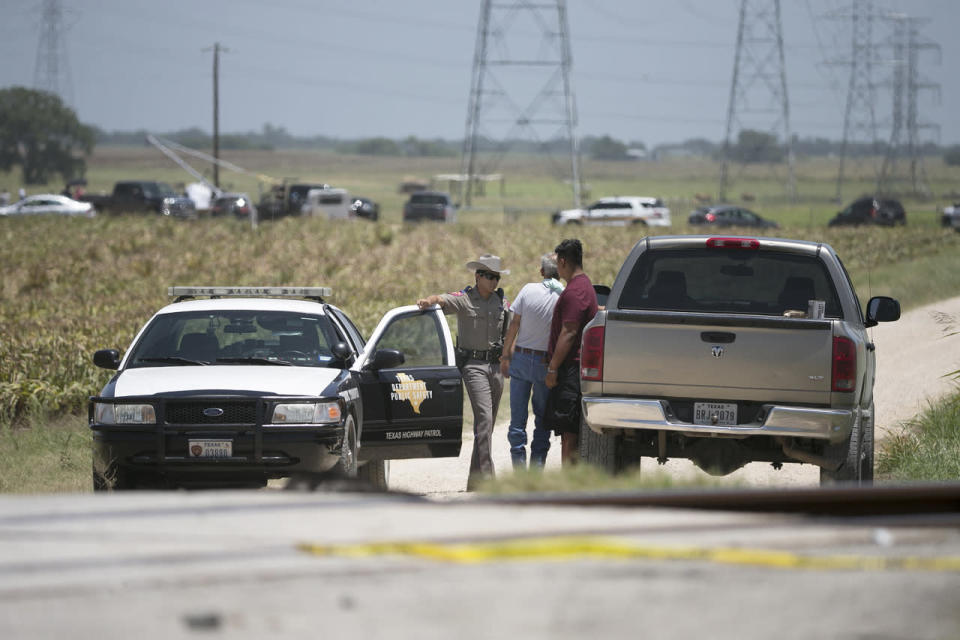 <p>A DPS trooper talks with men at a checkpoint near the scene of Saturday’s hot air balloon crash near Lockhart, Texas, Monday, Aug. 1, 2016. (Deborah Cannon/Austin American-Statesman via AP)</p>