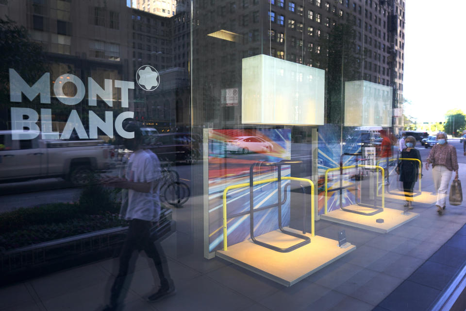 CORRECTS YEAR TO 2020 NOT 2019 Pedestrians walk past an empty window display at the Mont Blanc store on Chicago's Magnificent Mile on Tuesday, Aug. 11, 2020. Store owners in and around Chicago's Michigan Avenue are asking themselves if of the economics and reputation of one America’s most prestigious shopping districts can rebound from the damage caused by looting this week. Businesses had been slowly reopening after pandemic-related shutdowns. (AP Photo/Charles Rex Arbogast)