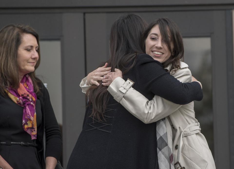 Michelle Susan Hadley, right, hugs Orange County District Attorney Chief of Staff Susan Kang Schroeder after being cleared of all charges in a complicated plot to frame her in Fullerton, Calif., Monday, Jan. 9, 2017. Hadley has been exonerated of charges that she placed "rape fantasy" ads on Craigslist in order to get men to attack her ex-boyfriend's new wife. Prosecutors now say that it was the alleged victim in the case who was trying to frame her husband's ex by placing the malicious ads. Her mother, Suzanne Hadley, is at left. (Jeff Gritchen/The Orange County Register via AP)