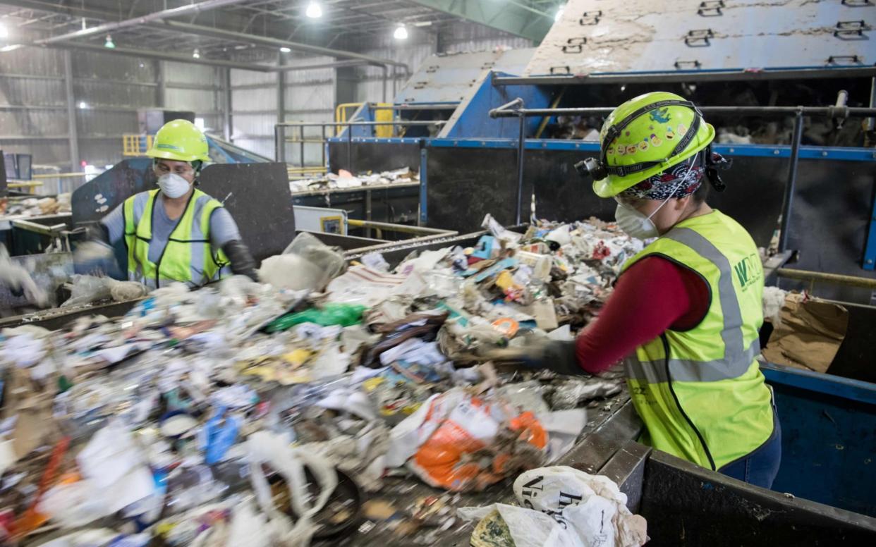 Workers sort recycling material - AFP