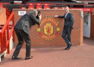 Manchester United's Scottish manager David Moyes poses for photographers beside the Manchester United club crest at Old Trafford in Manchester, northwest England on July 5, 2013