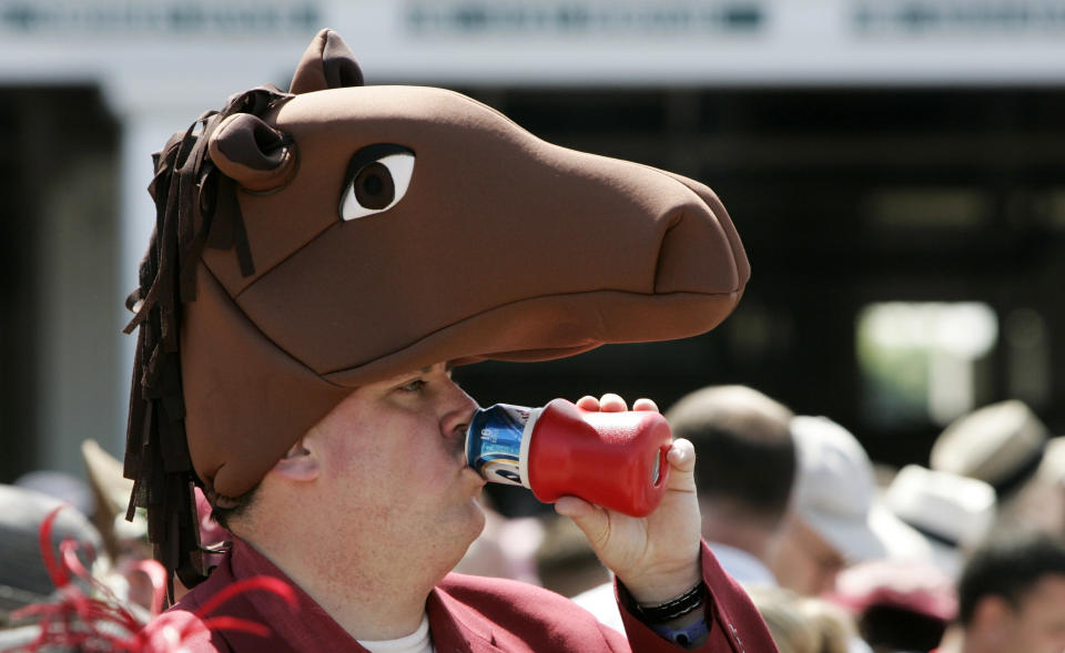 A race fan drinks a beer as he wears a horse hat&nbsp;before the 2008 derby.&nbsp;