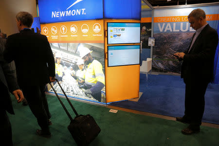 FILE PHOTO: Visitors pass the Newmont Mining Corporation booth during the Prospectors and Developers Association of Canada (PDAC) annual convention in Toronto, Ontario, Canada March 4, 2019. REUTERS/Chris Helgren/File Photo