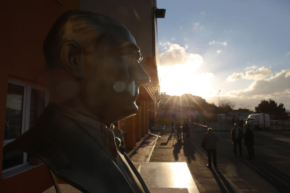 A statue of Turkish Republic founder Mustafa Kemal Ataturk is seen outside of a polling station as voters walk towards to cast they vote in Istanbul, Sunday, March 31, 2019. Turkish citizens have begun casting votes in municipal elections for mayors, local assembly representatives and neighborhood or village administrators that are seen as a barometer of Erdogan's popularity amid a sharp economic downturn. (AP Photo/Lefteris Pitarakis)