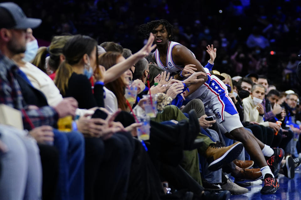 Philadelphia 76ers' Tyrese Maxey falls into the seats after chasing a loose ball during the first half of an NBA basketball game against the Orlando Magic, Wednesday, Jan. 19, 2022, in Philadelphia. (AP Photo/Matt Slocum)