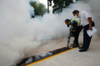 A worker fogs the drains in the common areas of a public housing estate at an area where locally transmitted Zika cases were discovered in Singapore August 31, 2016. REUTERS/Edgar Su