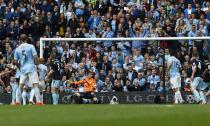 Manchester City's captain Vincent Kompany (3rd L) shoots and scores against West Ham United during their English Premier League soccer match at the Etihad Stadium in Manchester, northern England May 11, 2014. REUTERS/Darren Staples (BRITAIN - Tags: SPORT SOCCER) FOR EDITORIAL USE ONLY. NOT FOR SALE FOR MARKETING OR ADVERTISING CAMPAIGNS. NO USE WITH UNAUTHORIZED AUDIO, VIDEO, DATA, FIXTURE LISTS, CLUB/LEAGUE LOGOS OR "LIVE" SERVICES. ONLINE IN-MATCH USE LIMITED TO 45 IMAGES, NO VIDEO EMULATION. NO USE IN BETTING, GAMES OR SINGLE CLUB/LEAGUE/PLAYER PUBLICATIONS