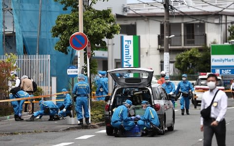 Police forensic experts are seen at the crime scene where a man stabbed 19 people, including children in Kawasaki - Credit: AFP