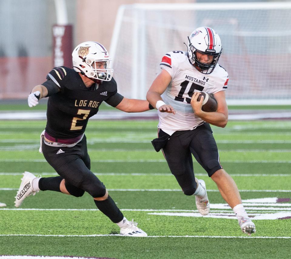 McDonald County QB Destyn Dowd runs for yardage against Logan-Rogersville defenders Caleb Cole (2) on September 9, 2022.