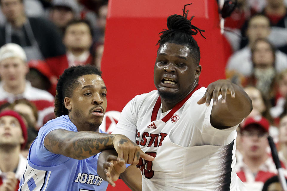 North Carolina State's DJ Burns Jr., right, battles with North Carolina's Armando Bacot, left, under the basket during the first half of an NCAA college basketball game in Raleigh, N.C., Wednesday, Jan. 10, 2024. (AP Photo/Karl B DeBlaker)