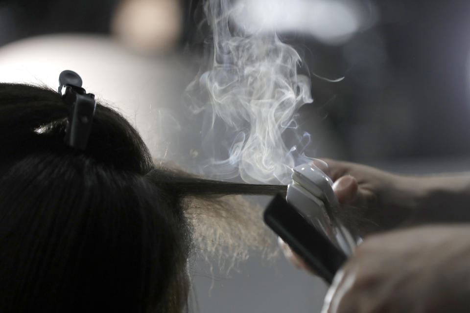 FILE - Steam rises as a hair stylist works on a model prior to a show displaying the Tom Ford collection during Fashion Week on Feb. 6, 2019, in New York. People of color in the industry trace bias and discrimination in predominantly white salons to the sidelining of formal education focused on Black hair. Horror stories are not uncommon, from outright refusal of service to botched treatments and cuts by stylists who don't know what they're doing. (AP Photo/Julio Cortez, File)