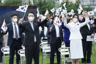 South Korean President Yoon Suk Yeol, second from left, and his wife Kim Keon Hee give three cheers for his country during a ceremony to celebrate Korean Liberation Day from Japanese colonial rule in 1945, at the presidential office square in Seoul, South Korea, Monday, Aug. 15, 2022. (AP Photo/Ahn Young-joon, Pool)