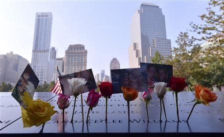 Flowers and pictures are left along the North Pool of the 9/11 Memorial during a ceremony marking the 12th anniversary of the 9/11 attacks on the World Trade Center in New York September 11, 2013. REUTERS/Justin Lane/Pool