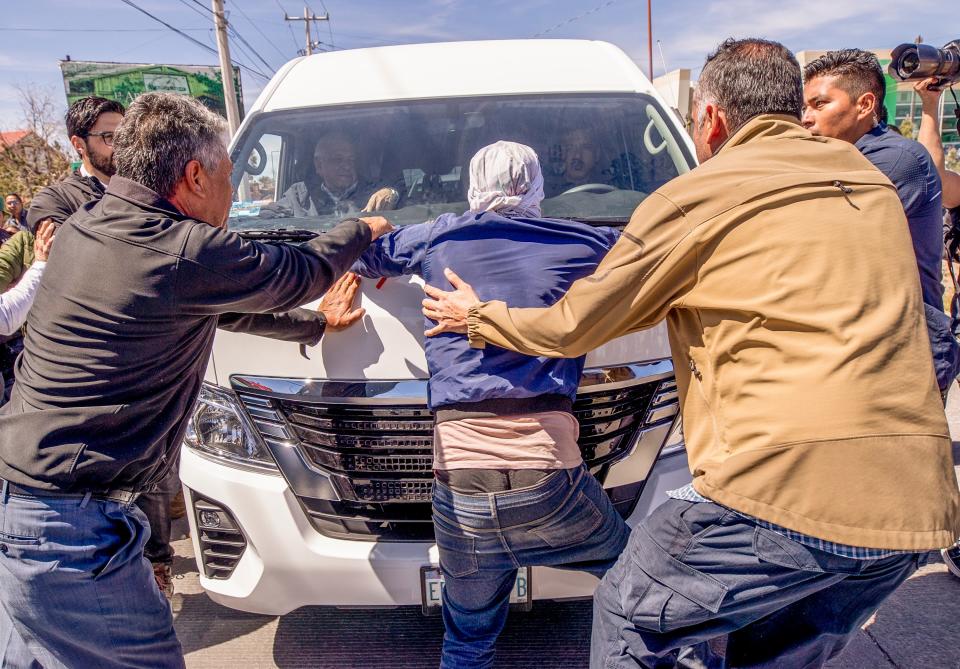 Mexican President Andres Manuel Lopez Obrador observes as his security tries to remove a Venezuelan migrant who attempted to stop the president’s vehicle as the president exited Colegio de Bachilleres school in Ciudad Juarez during his visit on March 31, 2023.