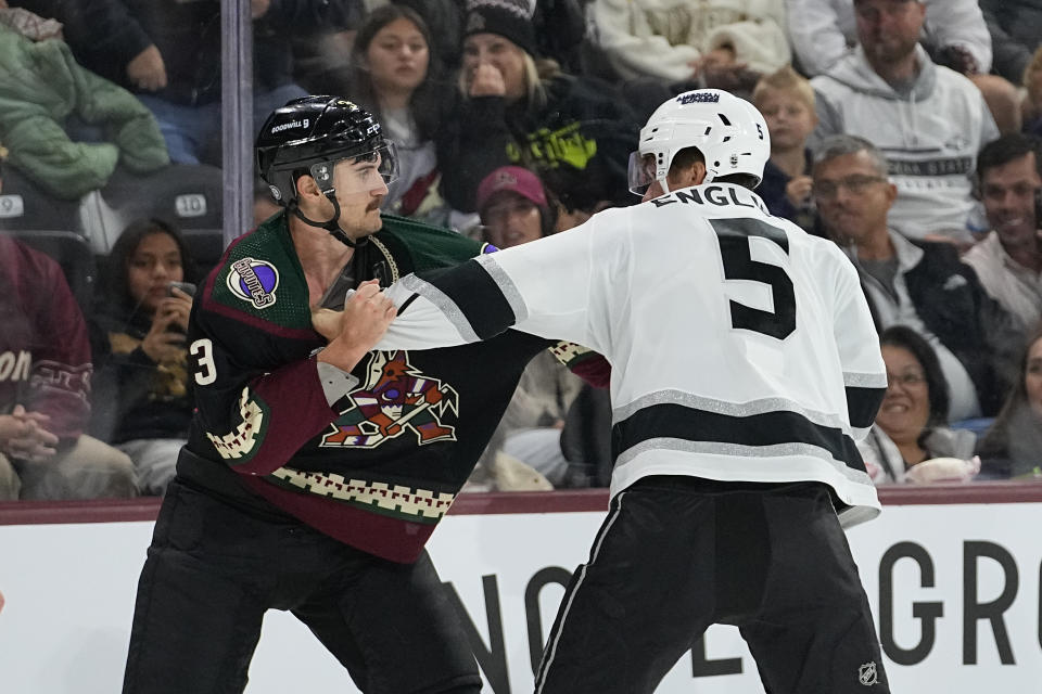 Los Angeles Kings defenseman Andreas Englund (5) and Arizona Coyotes defenseman Josh Brown (3) fight during the first period of an NHL hockey game, Monday, Nov. 20, 2023, in Tempe, Ariz. (AP Photo/Matt York)