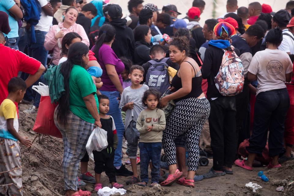 Migrants await on the north embankment of the Rio Grande to see if the Texas National Guard would allow them to turn themselves to U.S. Border Patrol on Sept. 12, 2023.