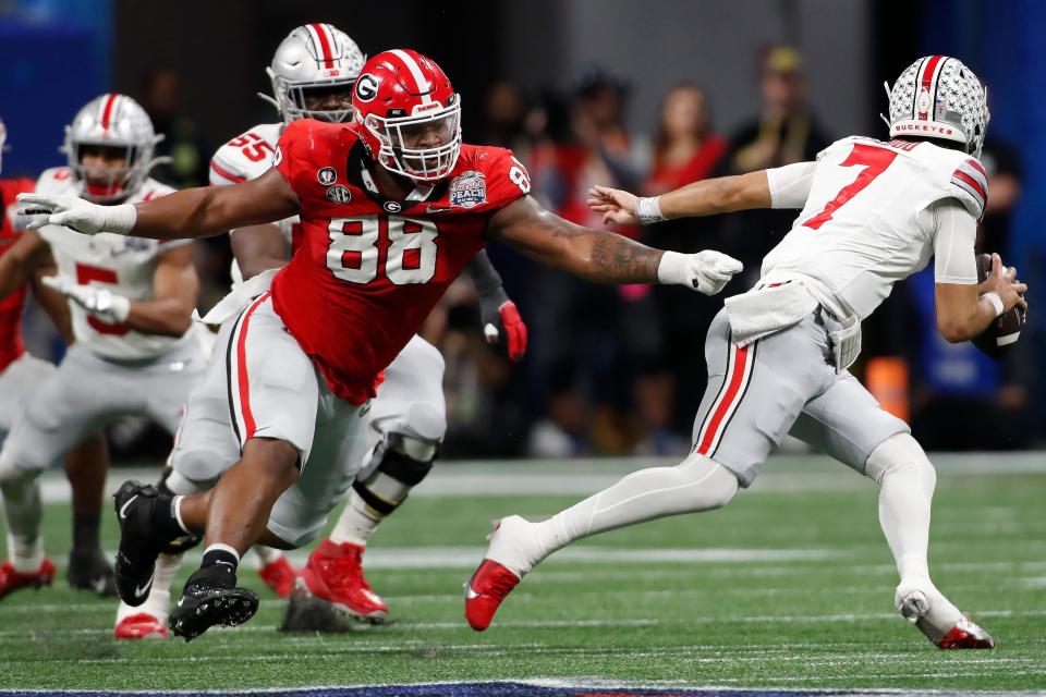 Ohio State quarterback C.J. Stroud (7) escapes a tackle from Georgia defensive lineman Jalen Carter (88) during the first half of the Chick-fil-A Peach Bowl NCAA College Football Playoff semifinal game on Saturday, Dec 31, 2022, in Atlanta.

News Joshua L Jones