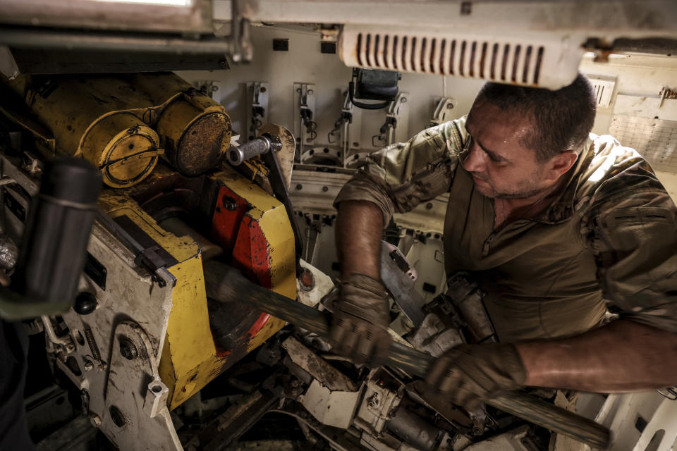 In this photo provided by Ukraine's 24th Mechanised Brigade press service, a serviceman prepares to fire a "Gvozdika" 120mm Soviet-made howitzer towards Russian positions at outskirts of Chasiv Yar, Donetsk region, Ukraine, Saturday, June 22, 2024, (Oleg Petrasiuk/Ukraine's 24th Mechanised Brigade via AP)