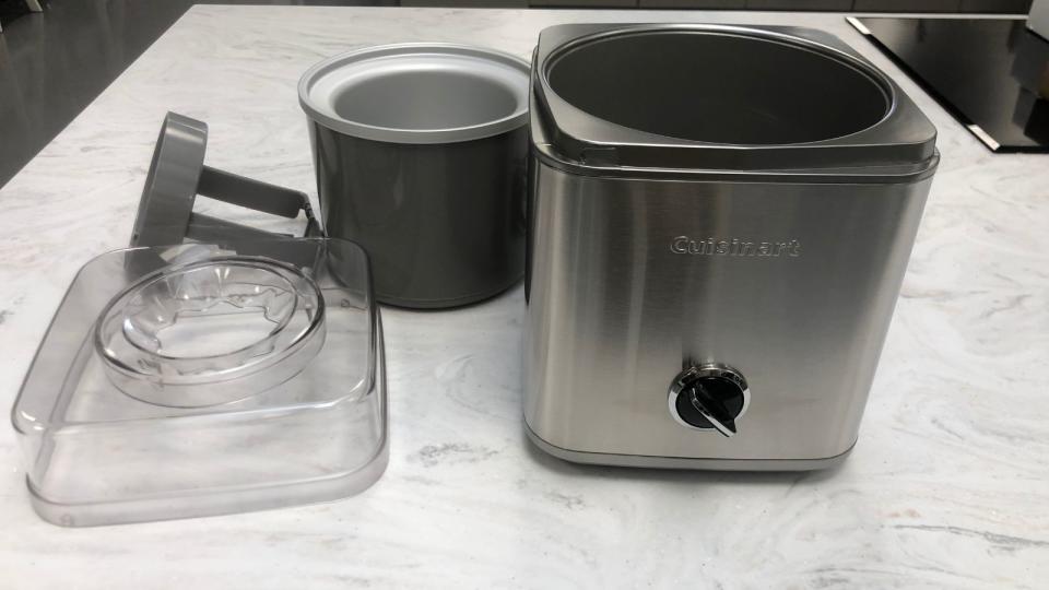 Cuisinart Pure Indulgence Ice Cream Maker unboxed with the dasher, bowl and lid on a marble countertop