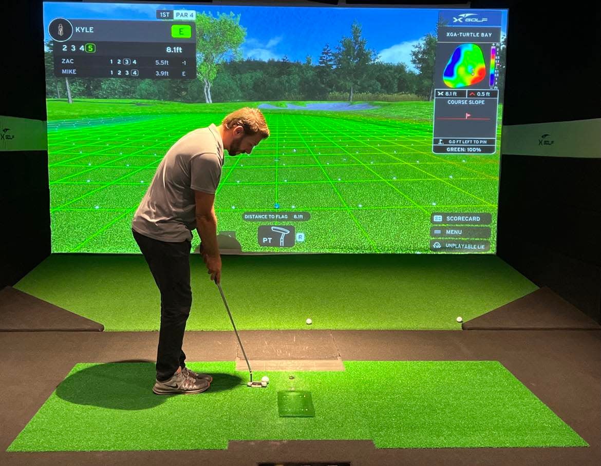 A golfer plays virtually at X-Golf in Jackson Township, one of several businesses, restaurants and bars where simulated golf is available in Stark County.