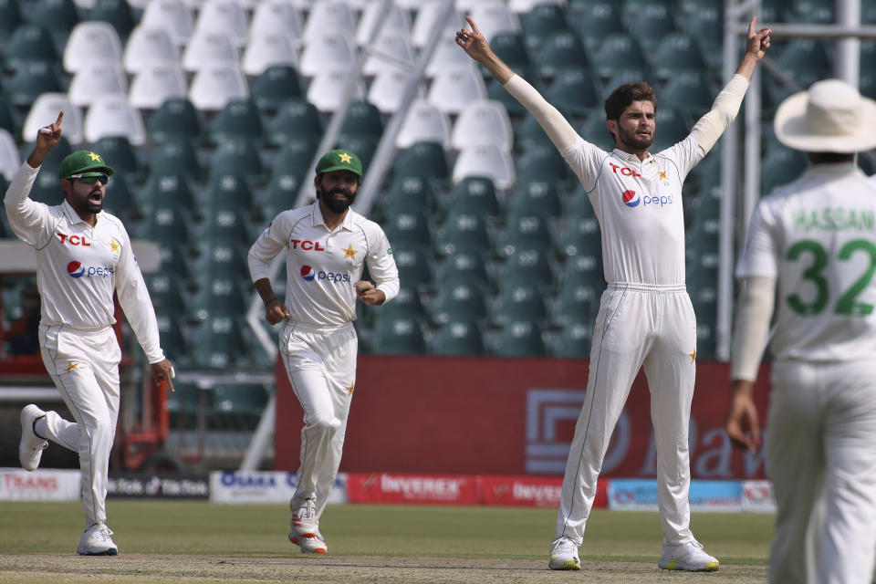 Pakistan's Shaheen Shah Afridi, second right, and teammates celebrate after the dismissal of Australia's David Warner on the first day of the third test match between Pakistan and Australia at the Gaddafi Stadium in Lahore, Pakistan, Monday, March 21, 2022. Australia won the toss and elected to bat first. (AP Photo/K.M. Chaudary)