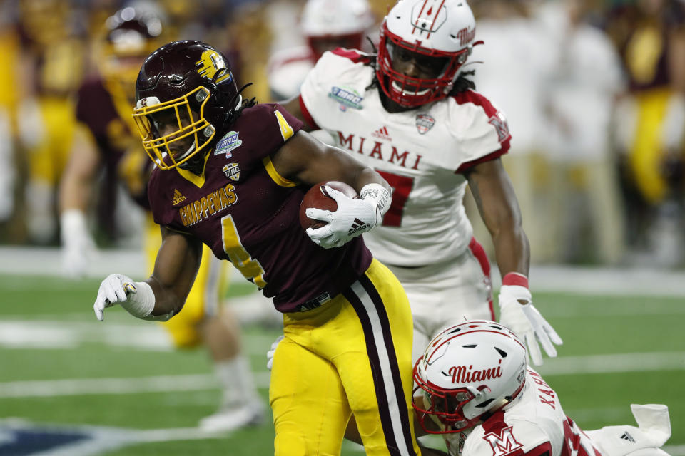 Central Michigan running back Kobe Lewis (4) is tackled by Miami of Ohio's Zach Kahn (29) during the first half of the Mid-American Conference championship NCAA college football game, Saturday, Dec. 7, 2019, in Detroit. (AP Photo/Carlos Osorio)