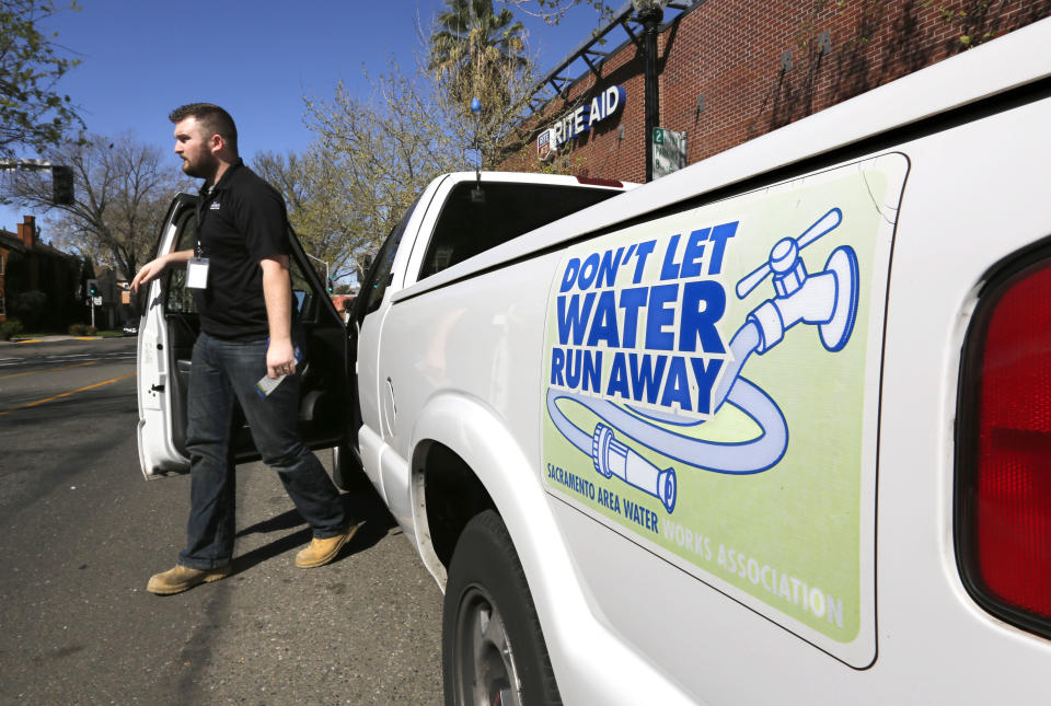 In this photo taken Tuesday, March 11, 2014, Steve Upton, an inspector for the water conservation unit for the Sacramento Utilities department, climbs out of his truck to make an inspection of an alleged water waste while making his rounds in Sacramento, Calif. At least 45 water agencies throughout California have imposed mandatory restrictions on water use as their supplies run dangerously low. In the first three months of the year, Sacramento has received 3,245 water waste complaints with officials issuing 350 violations in a recent two-day sweep to catch people watering their landscaping on the wrong days.(AP Photo/Rich Pedroncelli)