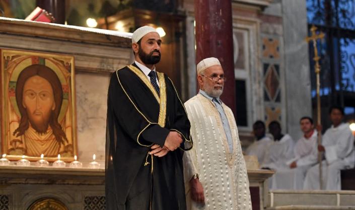 Iman Sami Salem (L) and Imam Mohammed ben Mohammed (R) stand during a mass in the church Santa Maria in trastevere in Rome on July 31, 2016 (AFP Photo/Tiziana Fabi)