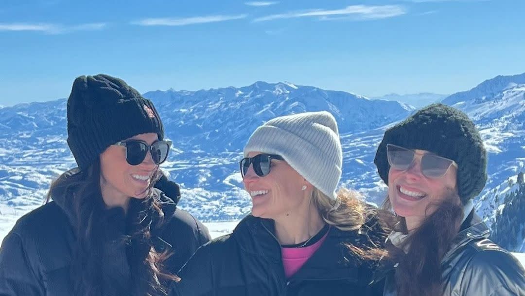 a group of women posing for a photo on a mountain