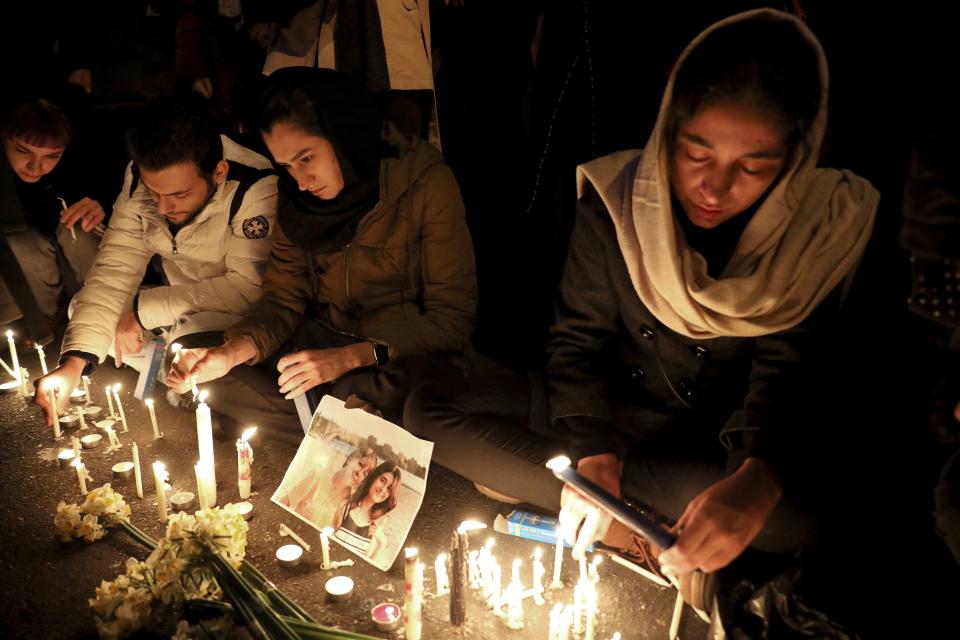 FILE - In this Jan. 11, 2020 file photo, people gather for a candlelight vigil to remember the victims of a Ukraine plane crash, at the gate of Amri Kabir University where some of the victims of the crash were former students, in Tehran, Iran. After a yearlong investigation, Iran's civil aviation agency on Wednesday released its final report on the crash of a Ukrainian passenger plane that killed 176 people last January, revealing no new details about the shootdown that has provoked outrage from affected countries and concerns from U.N. investigators. (AP Photo/Ebrahim Noroozi, File)