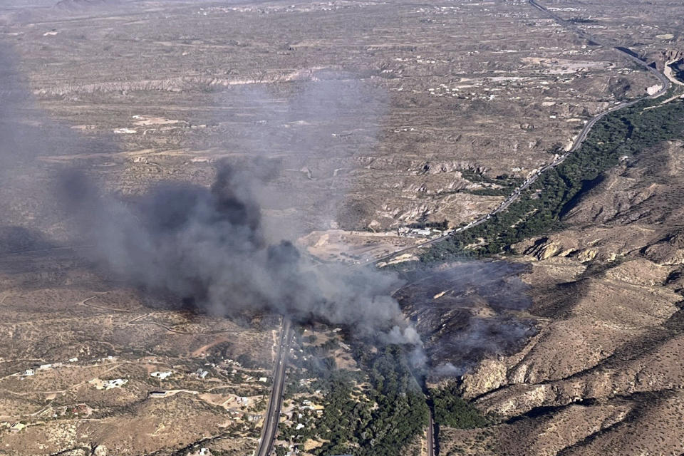 This image provided by the Arizona Department of Forestry and Fire Management shows smoke from the Rose Fire burning southeast of Wickenburg, Ariz., Wednesday, June 12, 2024. Officials say the fire destroyed several homes, prompted evacuations and forced the temporary closure of a highway while crews battled the flames. (Arizona Department of Forestry and Fire Management via AP)