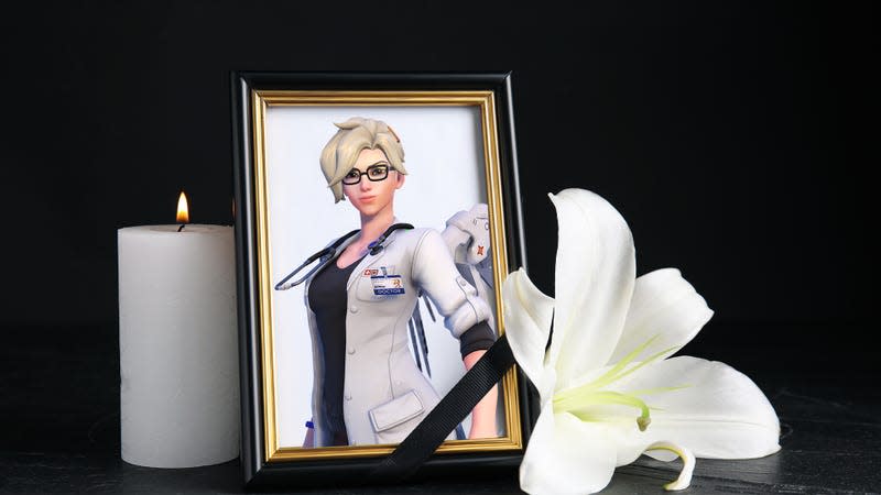 An image of Mercy in a picture frame appears next to a lit candle and a white flower.