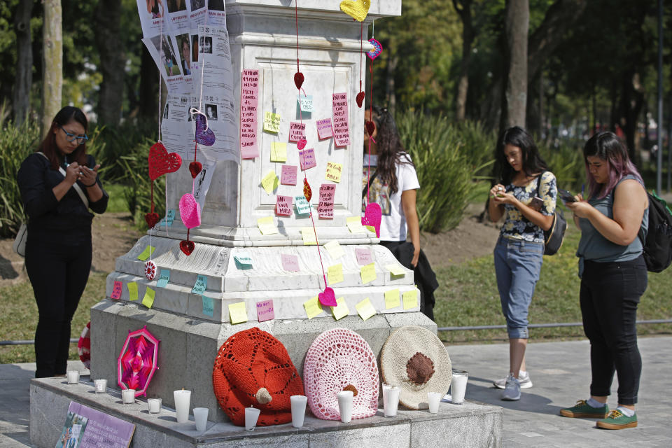 Women write the names of victims on post-it notes during a tribute for murdered women, in the Alameda park of Mexico City, Saturday, Aug. 24, 2019. A small group of women constructed a memorial made of hand-knit hearts. The knit-in on came on the heels of rowdy protests sparked by outrage over bungled investigations into alleged rapes of teenagers by local policemen. (AP Photo/Ginnette Riquelme)