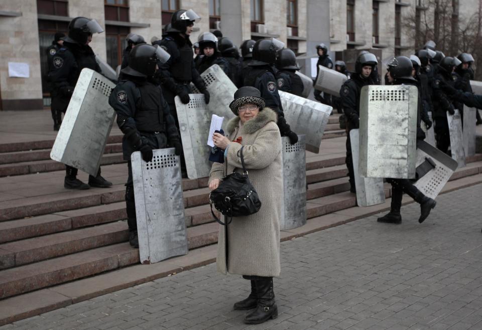 Riot police stand at the entrance of the regional administrative building during a rally in Donetsk, Ukraine, Wednesday, March 5, 2014. Hundreds of demonstrators waving Russian flags have stormed a government building in Donetsk in the eastern Ukraine. The region is the home area of fugitive Ukrainian President Viktor Yanukovych, who fled the country after massive protests in Kiev. (AP Photo/Sergei Chuzavkov)