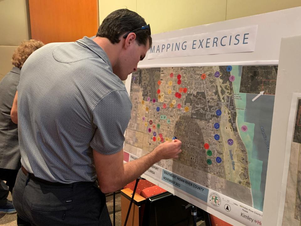 An unidentified meeting-goer puts stickers on a map set up by Kimley-Horn, Indian River County Comprehensive Plan consultants, Wednesday Nov. 29, 2023, at the county commission chambers. A series of county maps were set up to ask the public where they would like to see or not see certain development or preservation.