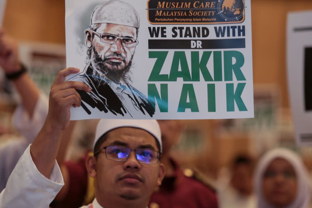 A PAS member holds up a placard to show his support for Dr Zakir Naik during Muktamar 2019 in Gambang, Pahang June 19, 2019. — Picture by Ahmad Zamzahuri