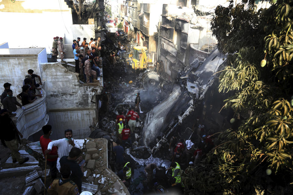 Voluntarios buscan sobrevivientes en un accidente de avión en una zona residencial de Karachi, en Pakistán, el 22 de mayo de 2020. (AP Foto/Fareed Khan)