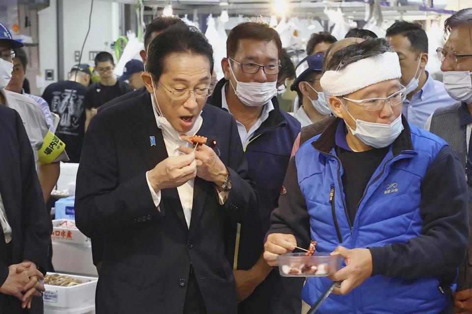 apan's Prime Minister Fumio Kishida, front left, tries a seafood at Toyosu fish market in Tokyo Thursday, 31 August 2023 (Kyodo News)