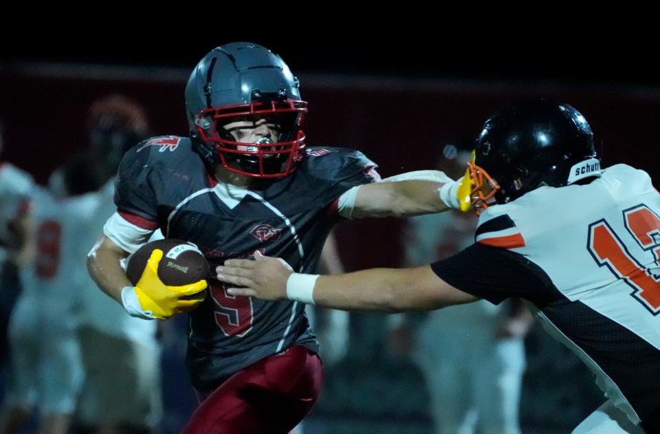 Falcon running back Jack Majcher holds off Wizard Isaac Casarez before he is taking down on a second quarter play.