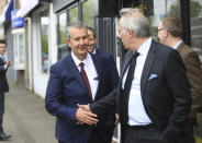 Democratic Unionist Party members Edwin Poots, left, is greeted by Ian Paisley jnr outside party headquarters in east Belfast after voting took place to elect a new leader on Friday May 14, 2021. Edwin Poots and Jeffrey Donaldson are running to replace Arlene Foster. (AP Photo/Peter Morrison)