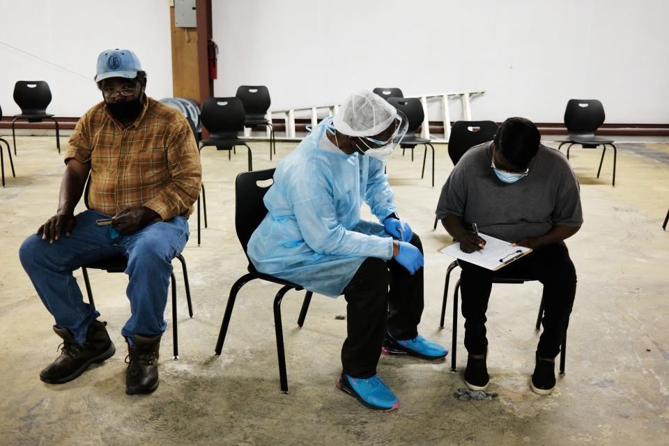 People prepare to get a shot of the Moderna COVID-19 vaccination from medical workers at a pop-up clinic operated by Delta Health Center on April 27, 2021, in Hollandale, Mississippi.