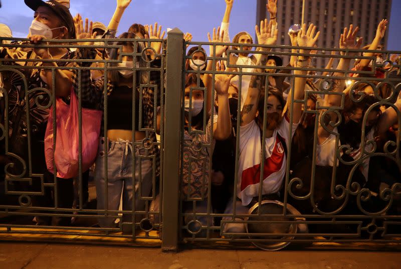 FILE PHOTO: People raise their arms during a minute of silence for people who died in recent street protests, during a demonstration against Congress and for a change in the country's constitution, in Lima