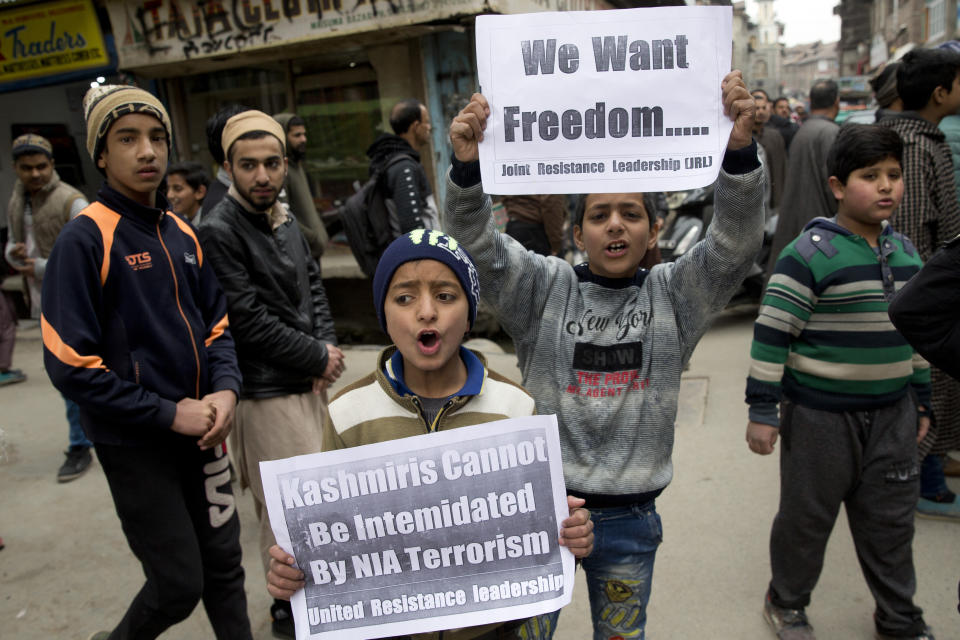 Kashmiri children hold placards and shout freedom slogans in Srinagar, Indian controlled Kashmir, Friday, March 1, 2019. India has banned Jama'at-e-Islami, a political-religious group in Kashmir, in a sweeping and ongoing crackdown against activists seeking the end of Indian rule in the disputed region amid the most serious confrontation between India and Pakistan in two decades. (AP Photo/ Dar Yasin)