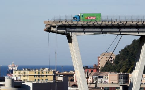 A truck is perched on the remaining section of the collapsed Morandi bridge - Credit:  STEFANO RELLANDINI/ REUTERS