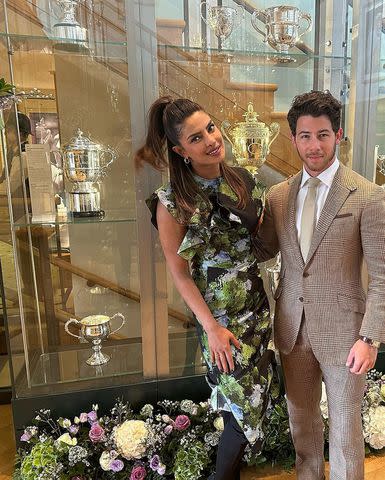 <p>Nick Jonas/Instagram</p> Nick Jonas and wife Priyanka Chopra Jonas pose in front of a Wimbledon trophy case.