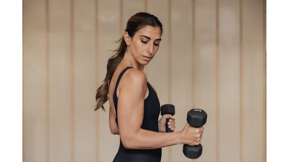 Woman flexing while holding dumbells 