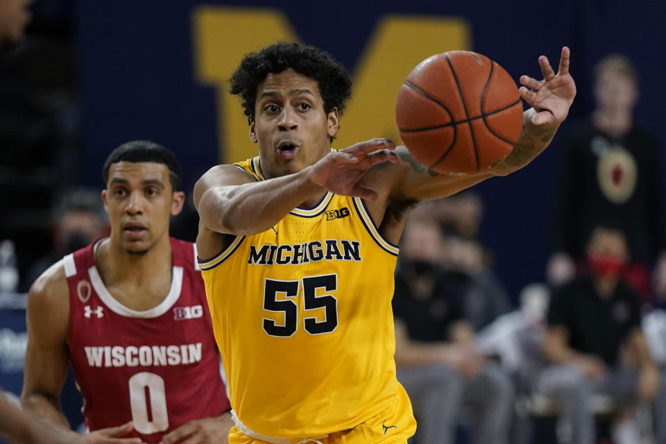 Michigan guard Eli Brooks (55) passes the ball, next to Wisconsin guard D'Mitrik Trice (0) during the second half of an NCAA college basketball game Tuesday, Jan. 12, 2021, in Ann Arbor, Mich. (AP Photo/Carlos Osorio)