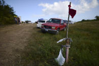 In this Friday, Jan. 10 photo, a red flag marks the entrance to a private hay farm where residents from the Indios neighborhood of Guayanilla, Puerto Rico are setting up shelter after earthquakes and continuing aftershocks in Guayanilla, Puerto Rico. A 6.4 magnitude quake that toppled or damaged hundreds of homes in southwestern Puerto Rico is raising concerns about where displaced families will live, while the island still struggles to rebuild from Hurricane Maria two years ago. (AP Photo/Carlos Giusti)