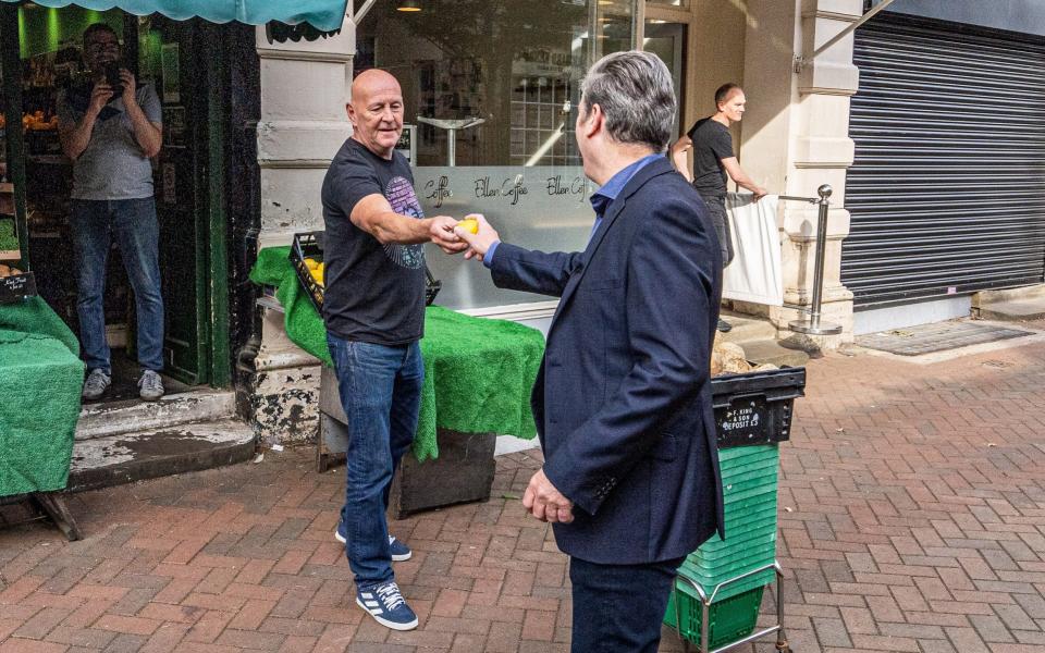 Sir Keir Starmer is handed a lemon during a walk through the town of Ossett this morning - Charlotte Graham