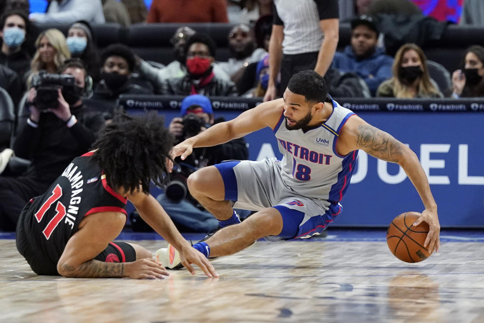 Detroit Pistons guard Cory Joseph (18) saves the ball as Toronto Raptors forward Justin Champagnie (11) defends during the second half of an NBA basketball game, Friday, Jan. 14, 2022, in Detroit. (AP Photo/Carlos Osorio)